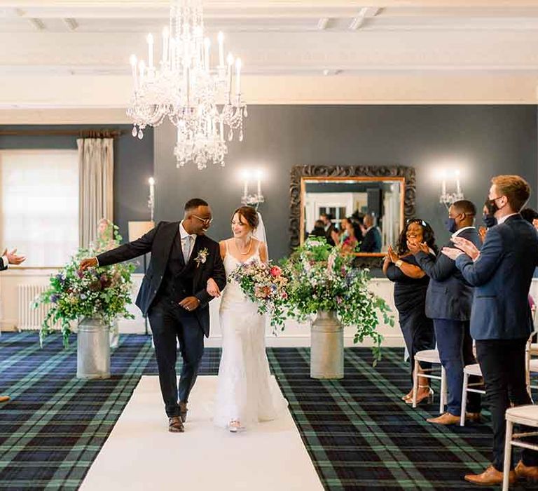 Bride & groom walk arm in arm on their wedding day 