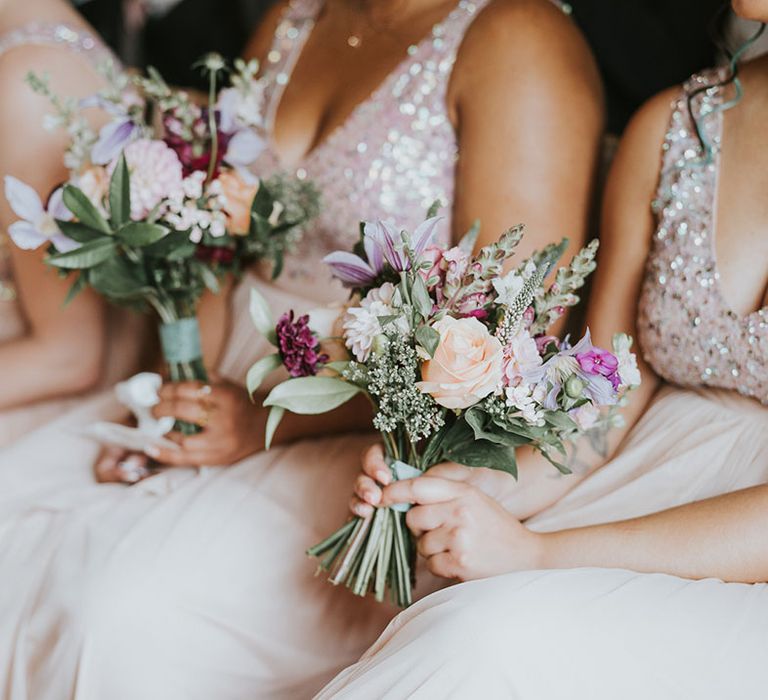 Purple, pink, orange, white wedding bouquets for bridesmaids with greenery