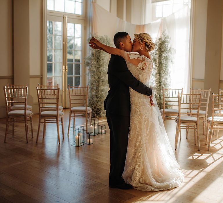 wedding ceremony room at Hodsock Priory with light flooding in the doors, drapes and gypsophila column flowers 