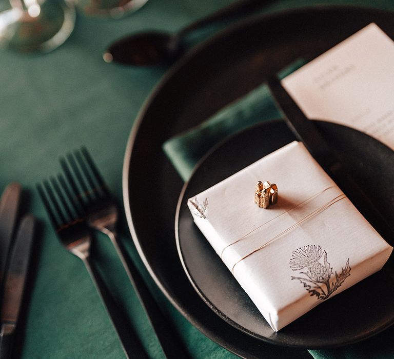 Green theme table setting with green tablecloth and napkins and wrapped up wedding present/favours for guests