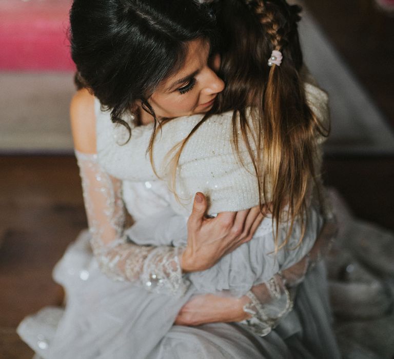 Bride in sparkly Zavana Couture wedding dress with flower girls in grey dresses with cardigans