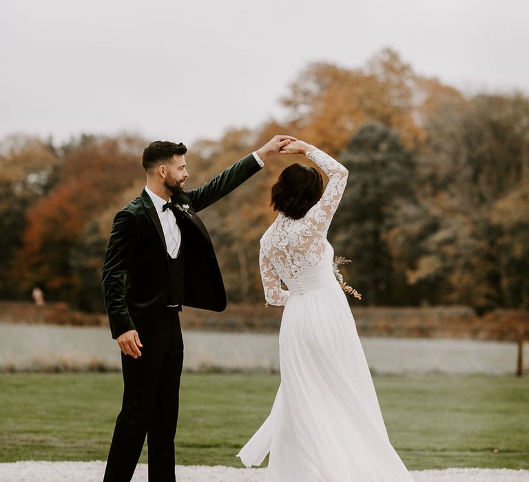 Groom spins the bride in lace wedding dress around