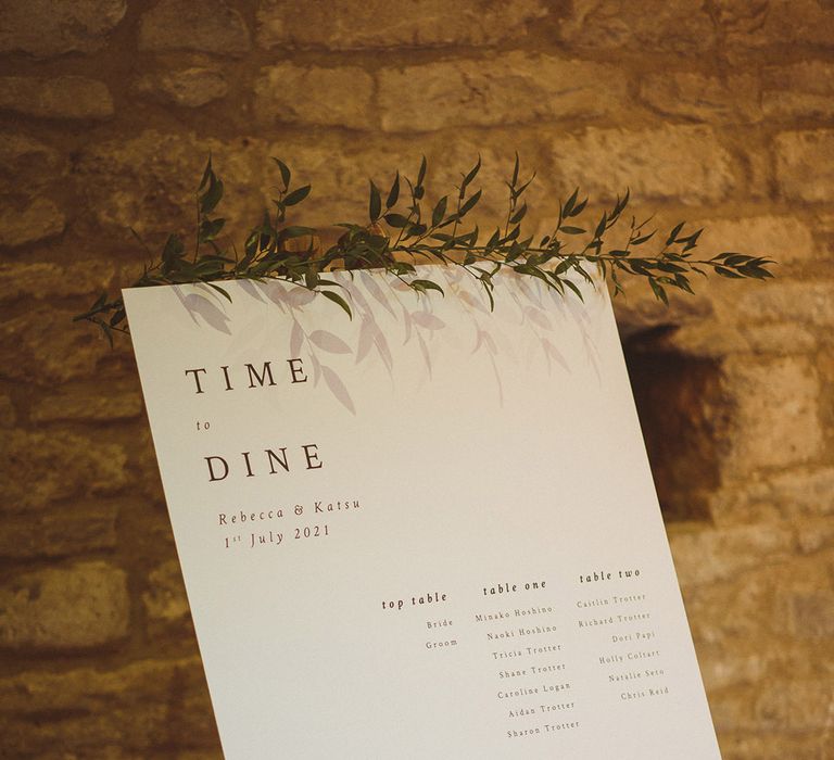 Black and white classic style wedding seating chart table plan on wooden easel with foliage for traditional barn wedding