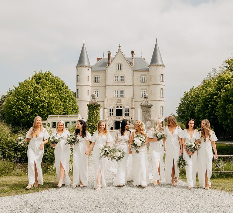 Bride party all in white with white flowers for classic chateau wedding 