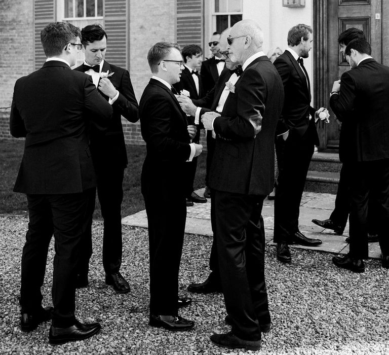 Wedding guests gather outside Findon Place for black tie wedding with classic styling 