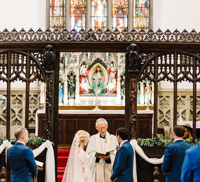 Bride & groom stand at the front of church on their wedding day before Tithe Barn reception 