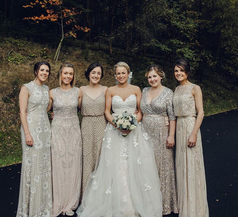 Bride in a sweetheart strapless wedding dress with the bridesmaids in pale grey sequin embellished bridesmaid dresses