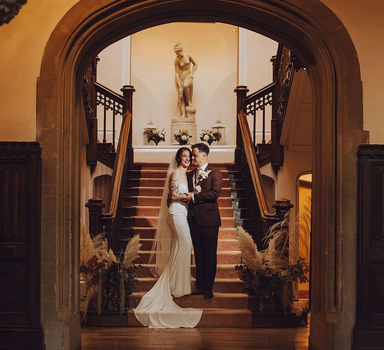 Bride & groom stand in the doorway at St Audries Park before wedding reception 