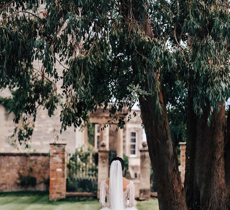 The bride walks in a tulle princess skirt wedding dress with long lace sleeves 