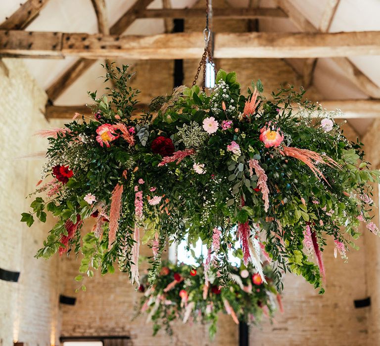 Suspended foliage decor with roses, peonies, pampas grass, eucalyptus and dried flowers hung in the ceiling beams