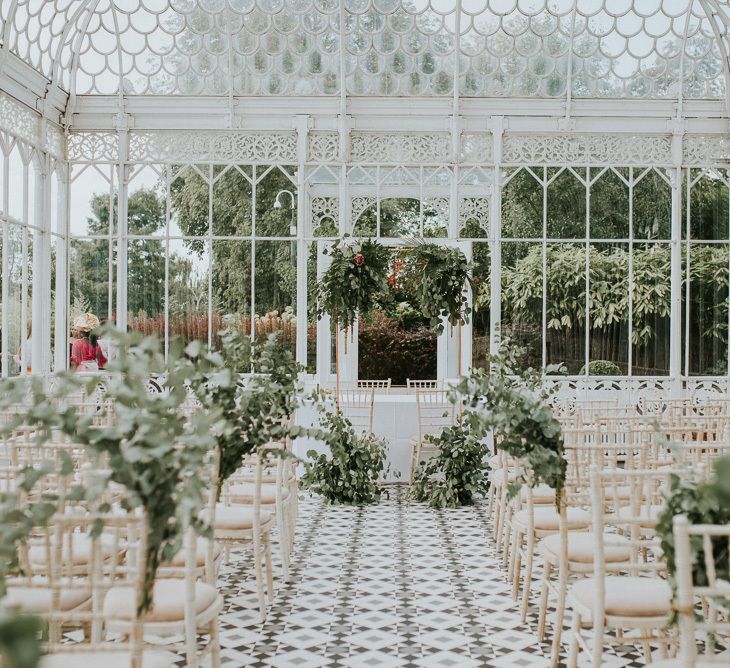 The Horniman Museum glasshouse wedding venue with eucalyptus aisle flowers and eucalyptus floral arrangements at the end of the alter 