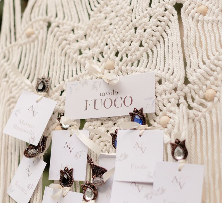 Macrame seating plan finished with brass clips and white stationery 