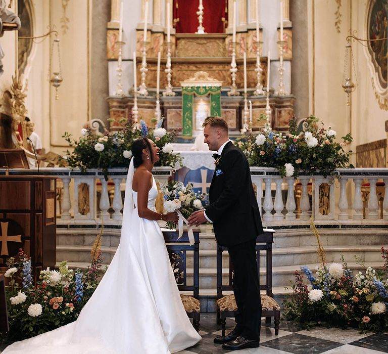 bride and groom exchanging vows at the altar in the church 