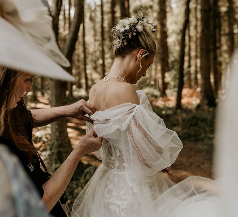 Bridesmaids help the bride put on her detachable wedding sleeves tog o with her Milla Nova wedding dress 