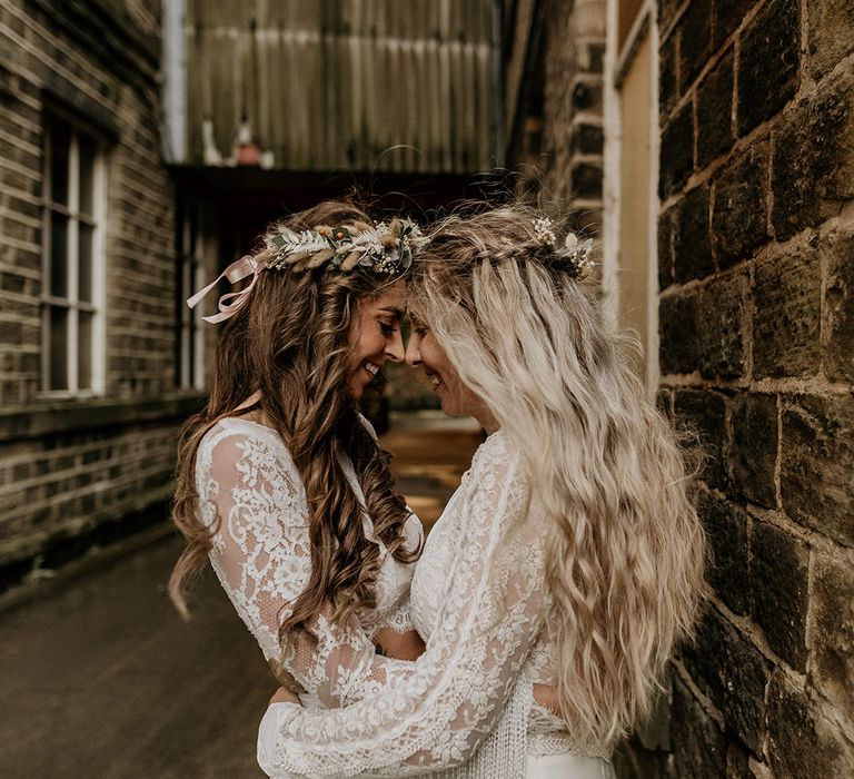 Brides with long wavy hair wearing flower crowns and hair accessories with long sleeve lace boho wedding dresses 