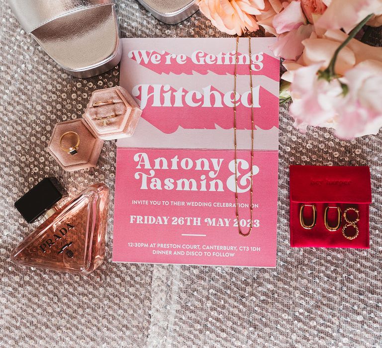 Square toe silver metallic shoes with Prada perfume, pink and white wedding stationery, with gold wedding jewellery 