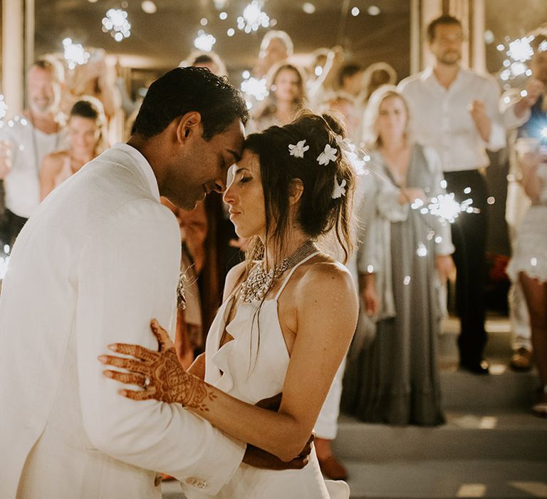 Bride and groom share first dance with guests waving sparklers around them