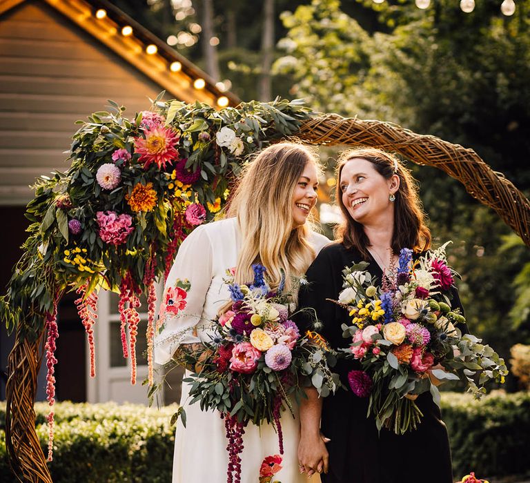 Boho moongate decoration moved to the outdoors to use as photo backdrop for the two brides at their same sex wedding 