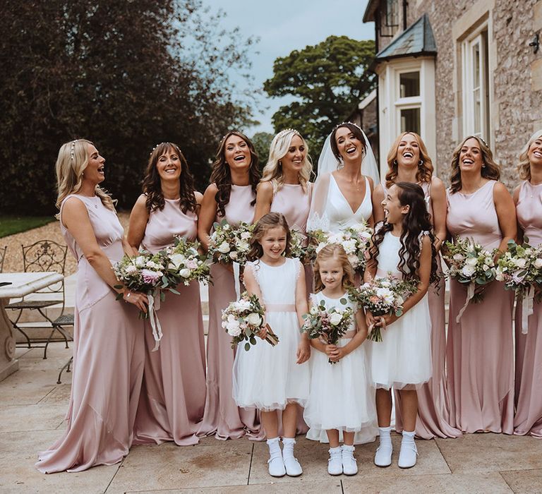 Blush pink theme wedding with bridesmaids in pink bridesmaid dresses with flower girls in white dresses