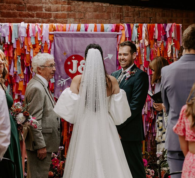 Bride in detachable puff sleeves for Suzanne Neville wedding dress with pearl wedding veil 