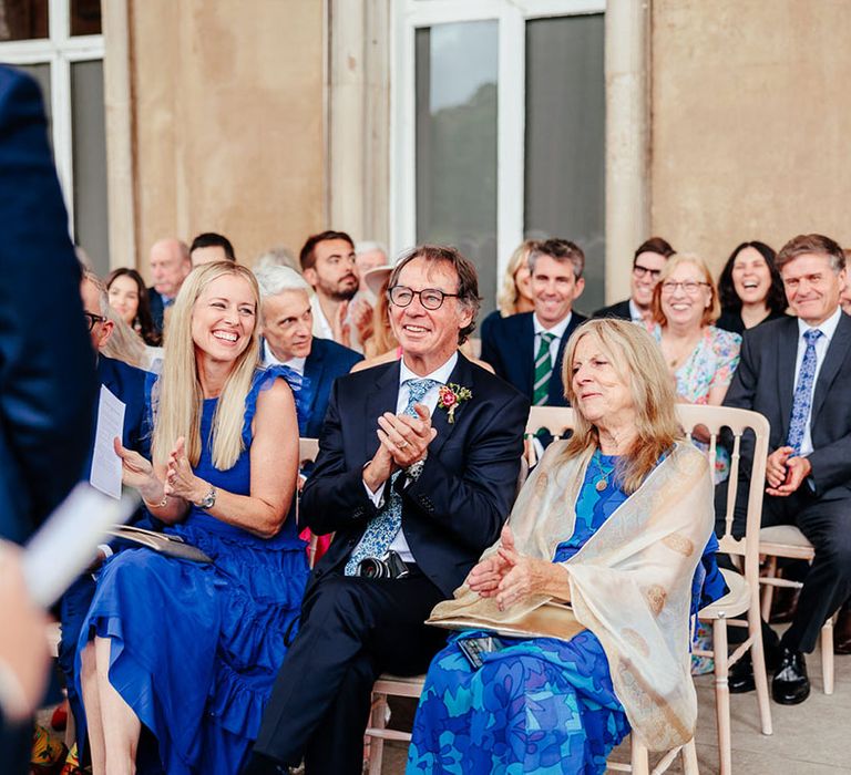 Wedding guests wearing bright blue outfits at wedding 