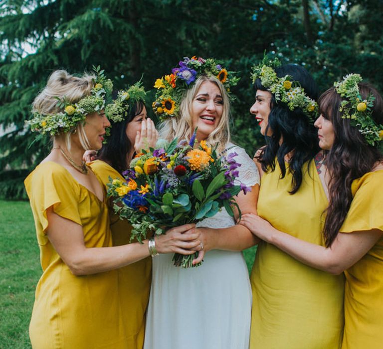 Boho wedding with bridal party wearing short sleeve yellow bridesmaid dresses with bride wearing colourful wedding flower crowns 