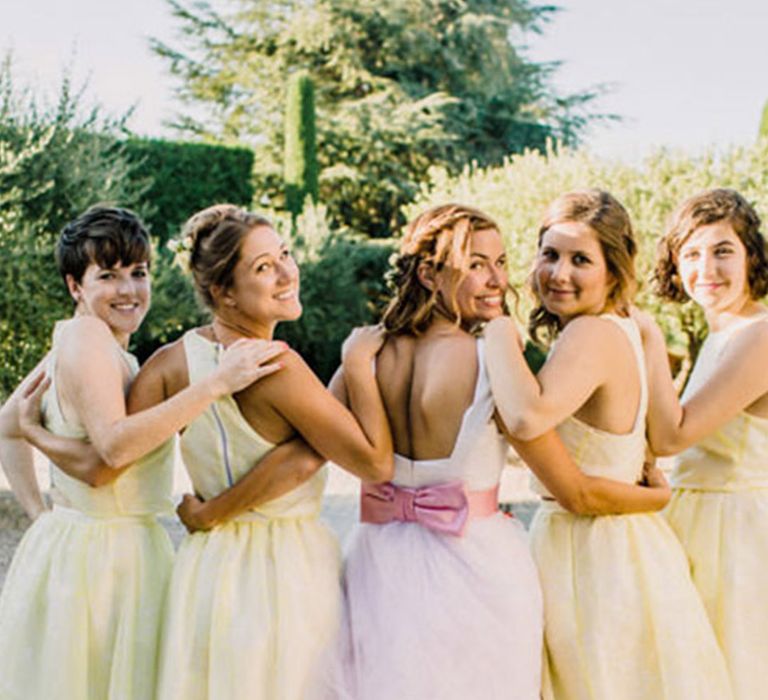 Bridal party wearing pastel yellow knee length bridesmaid dresses