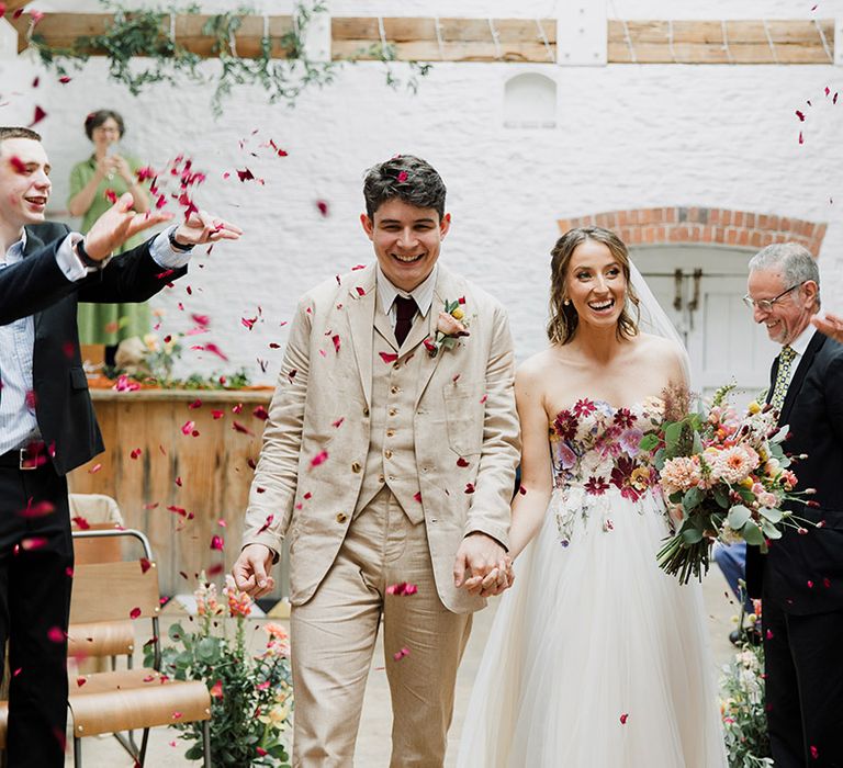 Confetti moment at The Silk Mill Studios for bride and groom with botanical wedding dress 