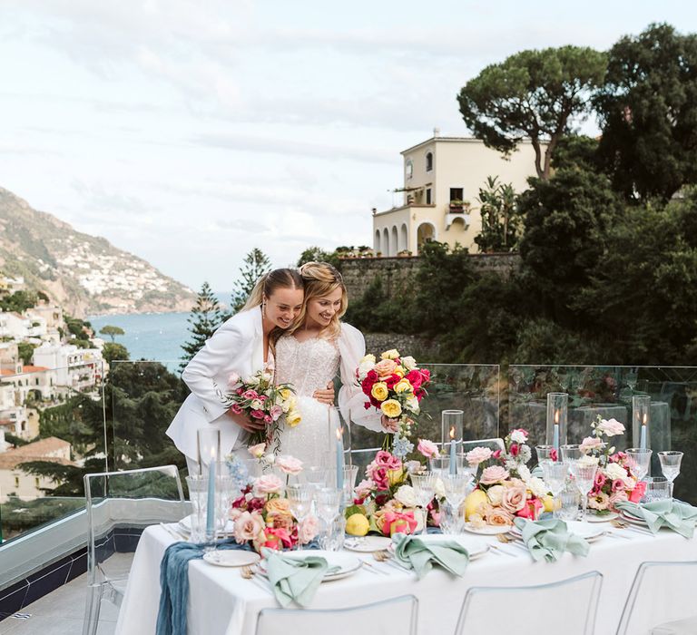 Bride in bridal suit and pink satin top with bride in a short wedding dress at the LGBTQI same sex wedding 