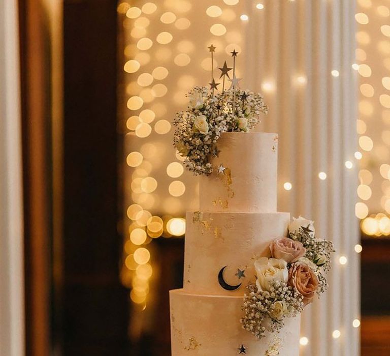 Three tier white wedding cake with metallic star decorations 