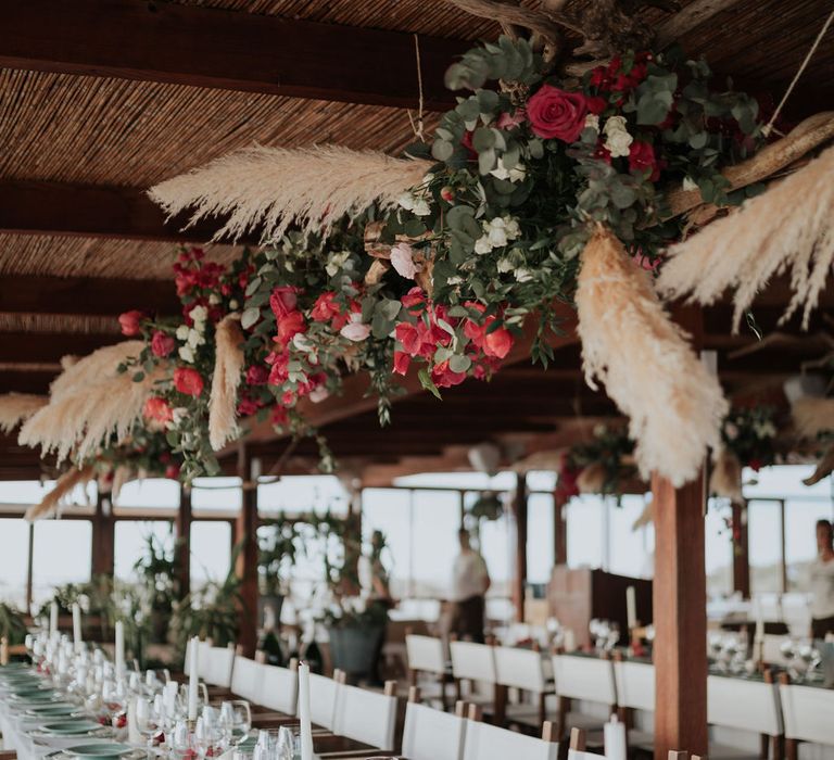 Beautiful wedding table set up with pink flower and pampas grass installation