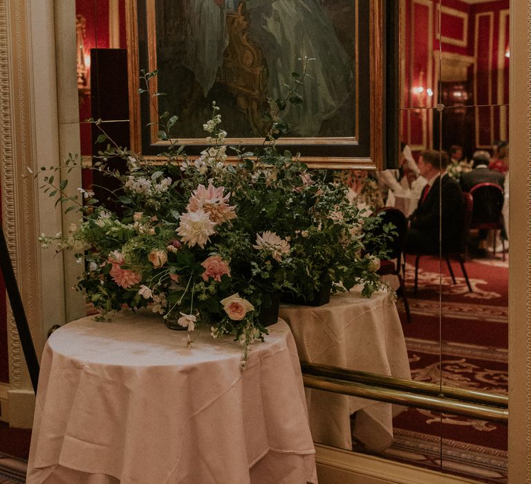 Royal Automobile Club wedding with portrait of the queen and stunning floral pink rose wedding installation 