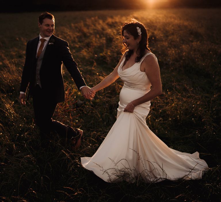 Bride & groom walk through the countryside in golden hour photoshoot