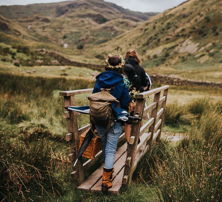 Bride & groom walk across bridge in the Lake District 