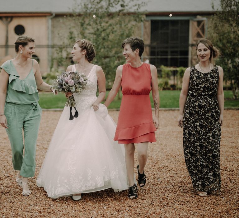 The bride and her bridesmaids in assorted wedding outfits