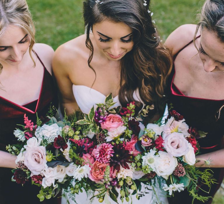 Bridal photography with bridesmaids - bright pink rose bridal bouquet and red velvet bridesmaid dresses 