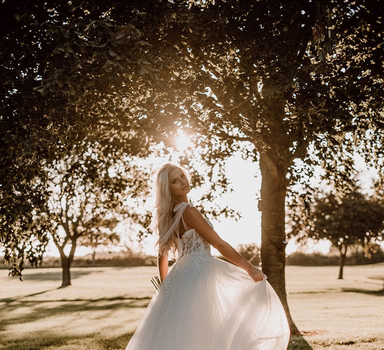 Bride in a polka dot tulle wedding dress with bow straps and fitted bodice 