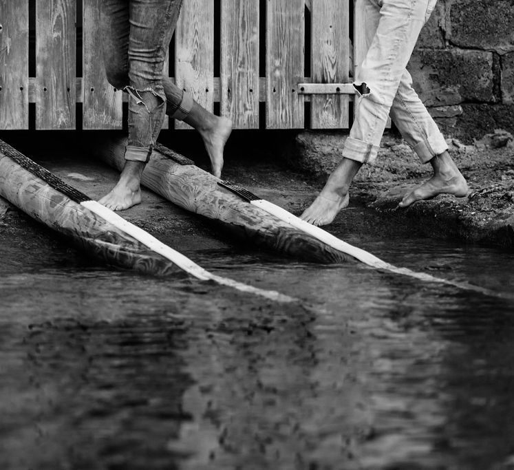 Black & white image of grooms walking along the sandbank together