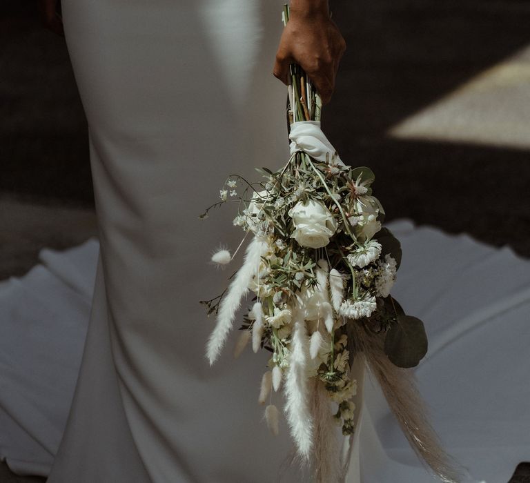 A white rose and dried grass bouquet. 