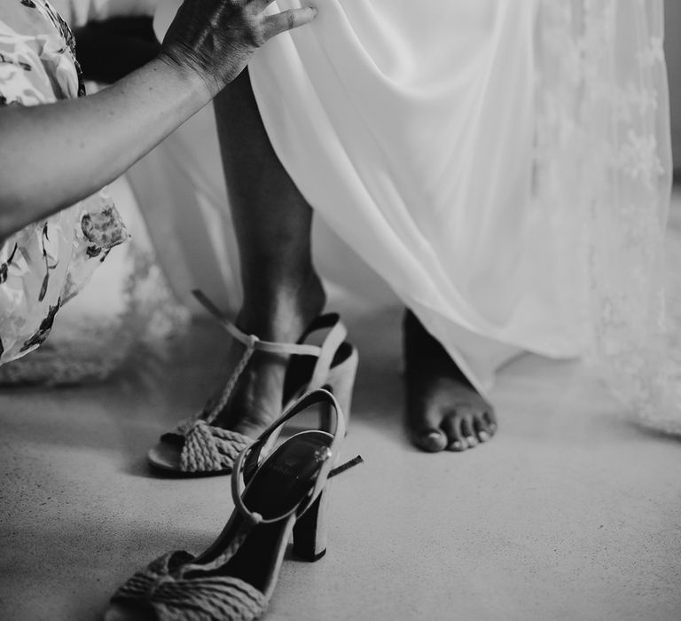 Bride puts on braided heeled sandal before summer wedding in Dorset 