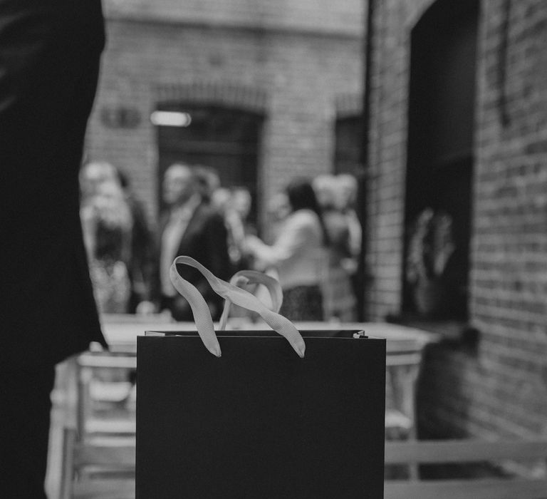 Rectangular bag reading 'YAY' on wooden table outside for wedding reception at Loft Studios London 