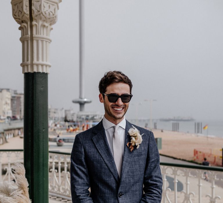 Groom in blue suit waits for bride's arrival