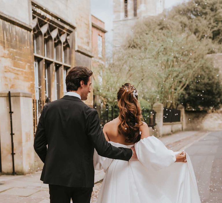 Confetti moment with bride in a strapless wedding with high wavy ponytail 