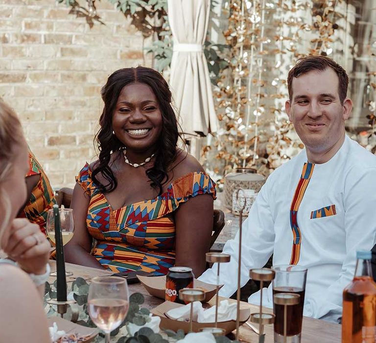 Bride & groom sit together on their wedding day for Airbnb wedding reception 