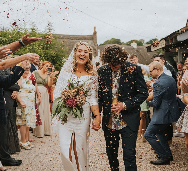 Bride & groom walk with one another through wedding guests