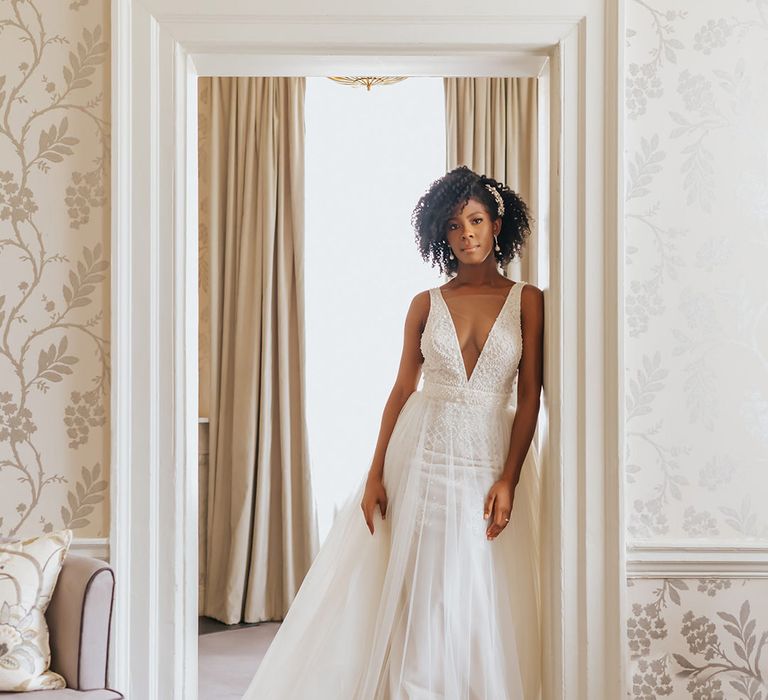 Beautiful black bride in a plunging neckline wedding dress with tulle skirt with naturally curly hair styled with a hair comb 