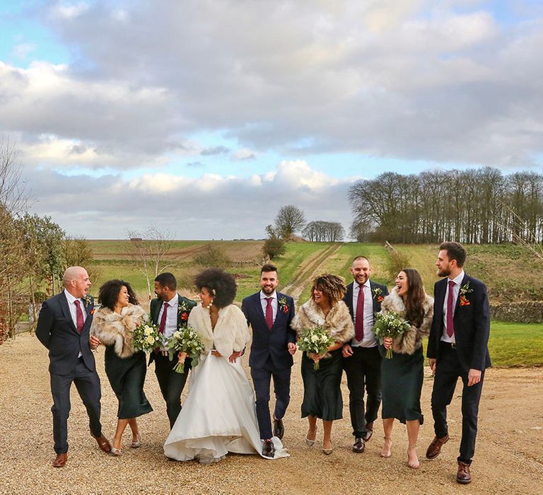 Bride & groom walk with their wedding party outdoors