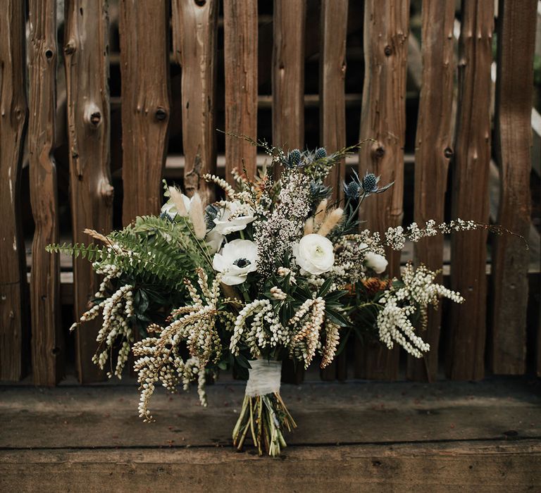 Natural wedding bouquet with anemones, snowdrops, foliage and dried grasses