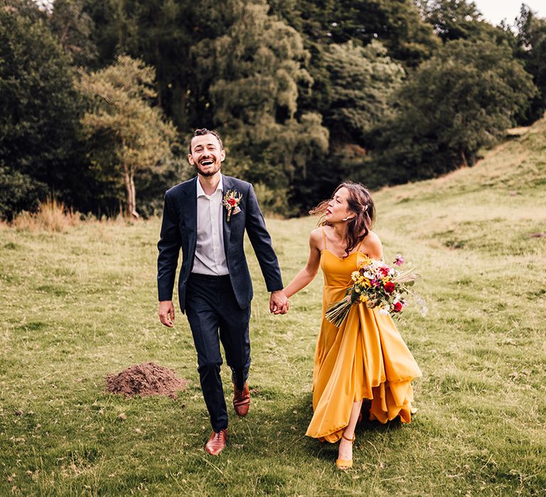 Bride & groom walk across hills 