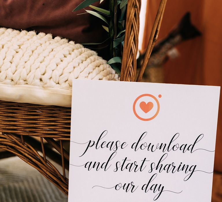 Wicker chair and small A4 sign with QR code for the wedding guests to share photos